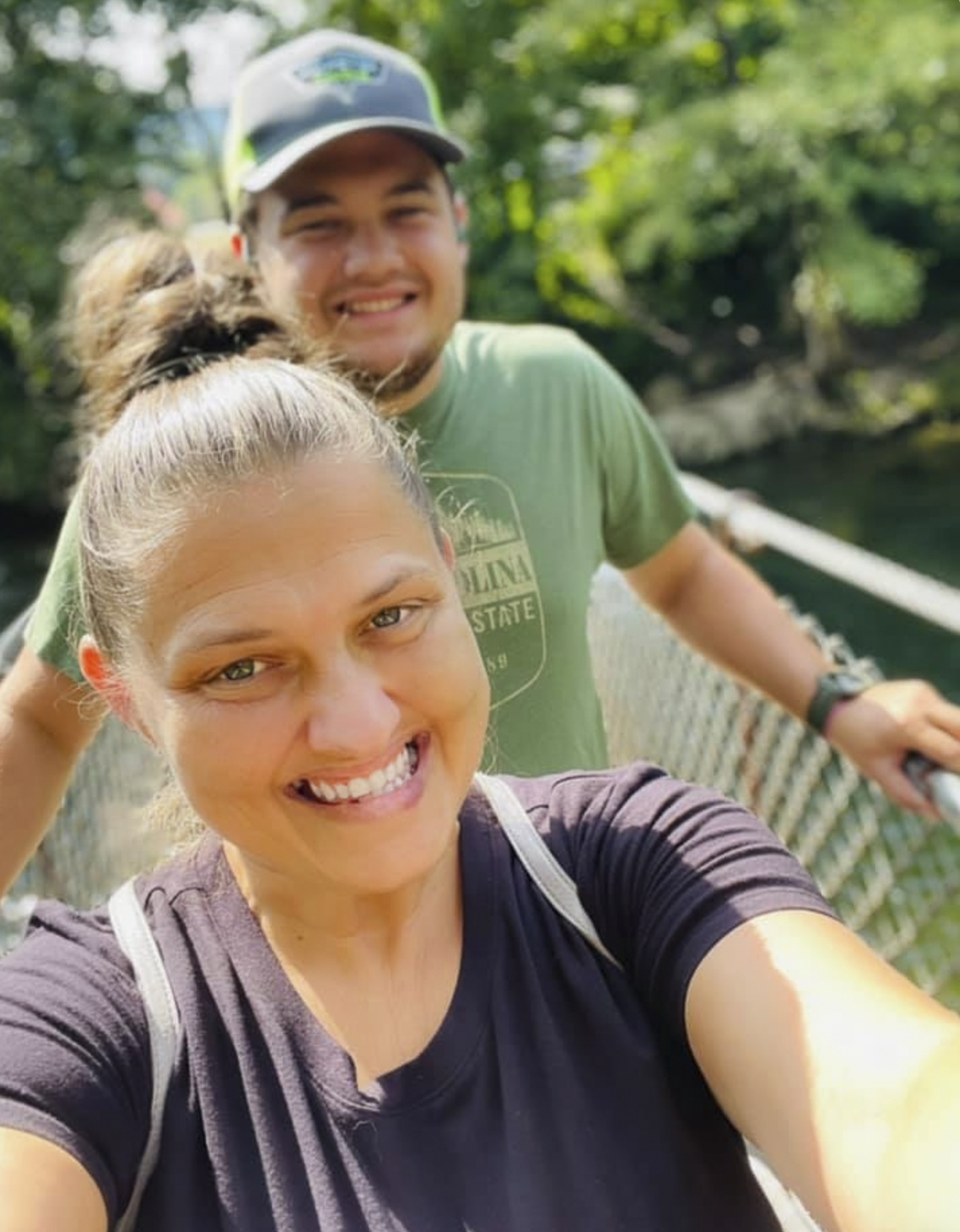 Kimberly with her son outdoors, smiling — a candid moment that grounds the family experience driving her work.